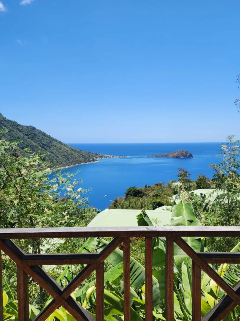 A wide turquoise bay framed by green hills in the Caribbean