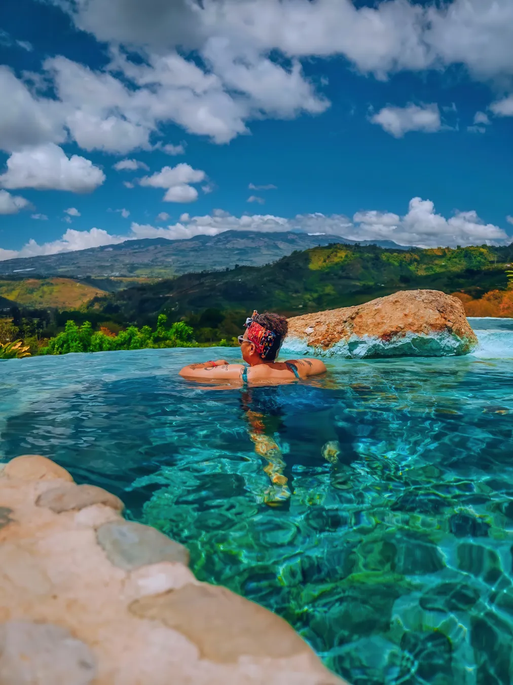 A traveler soaking in a warm volcanic hot spring in Costa Rica