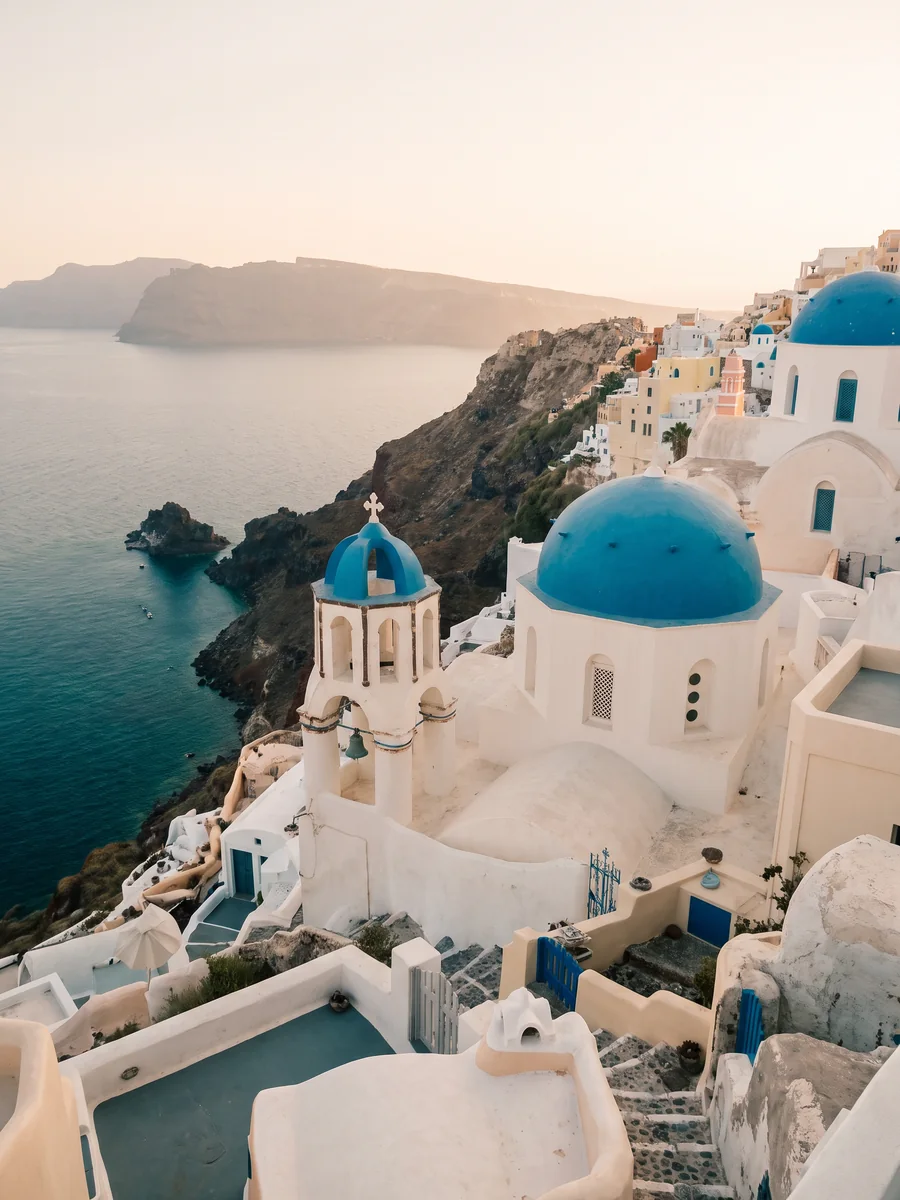 A blue-domed chapel above the deep blue Aegean in Santorini