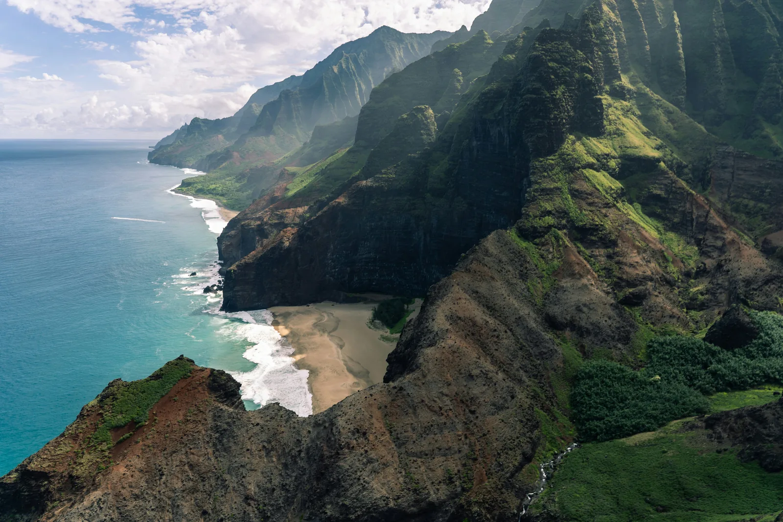 The dramatic green sea cliffs of the Na Pali Coast on Kauai catching soft light over the Pacific